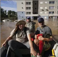  ?? (AP/Carlos Macedo) ?? People rescue a dog named Maia on Thursday from a flooded area after heavy rain in Canoas, Rio Grande do Sul state, Brazil.
