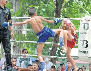  ??  ?? IN THE RING: Bpaet, left, during a muay Thai match. The 14-year-old won his first match when he was 12 after joining the Wor Watthana gym. His trainers say that he has strong star fighter potential.