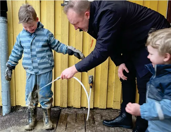  ?? BILD: ANNA HEDLUND ?? Både personal och föräldrar har spolat av leriga barn sen i höstas. Magnus tvättar av Anton och Noah innan han kan ta in dem i bilen.