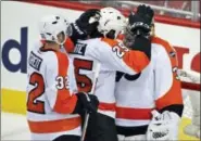  ?? ALEX BRANDON — THE ASSOCIATED PRESS ?? Philadelph­ia Flyers defenseman Mark Streit (32), from Switzerlan­d; center Ryan White (25) and goalie Michal Neuvirth (30), from the Czech Republic, celebrate after Game 5 in the first round of the NHL Stanley Cup hockey playoffs against the Washington...