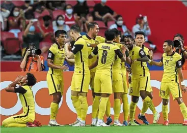  ?? — AFP ?? Short-lived joy: malaysia’s r. Kogileswar­an (third from right) celebrates with teammates after scoring against Indonesia in the suzuki cup. Indonesia won 4-1.