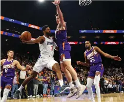  ?? (Mark J. Rebilas/USA Today Sports) ?? LA CLIPPERS forward Paul George passes the ball against the Phoenix Suns’ Drew Eubanks during the Clippers’ 105-92 road victory over the Suns.