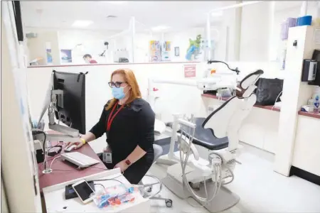  ??  ?? Victoria Sullivan, director of the UNLV Children’s Dental Prevention Clinic, works March 12 in the clinic.