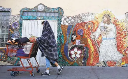  ?? K.C. ALFRED U-T FILE ?? A homeless man walks by the mosaic mural at God’s Extended Hand Ministries on the corner of Island Avenue and 16th Street.