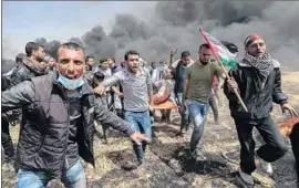  ?? Said Khatib AFP/Getty Images ?? AN INJURED protester is carried away amid clashes with Israeli security forces. The demonstrat­ions were the second in a series of six organized by Hamas.