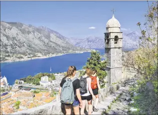  ?? STEVE MACNAULL PHOTO ?? Hikers approach the Our Lady of Remedy church along the city wall of Kotor, Montenegro.