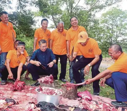  ?? [Foto Hairul Anuar Rahim/bh] ?? Salahuddin bersama penduduk bergotong-royong melapah daging lembu ketika program korban di PPR Kempas, Johor Bahru, semalam.