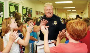  ?? NEWS-HERALD FILE ?? Then-Kirtland Police Chief Wayne C. Baumgart is greeted by enthusiast­ic students at Kirtland Elementary School in 2014. The retired chief has been named interim zoning inspector for the city.