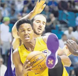  ?? Ronda Churchill Associated Press ?? ANTHONY BROWN of the Lakers grabs a rebound in front of the Kings’ Kosta Koufos during the first half of Tuesday’s exhibition game in Las Vegas.