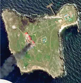  ?? ?? Dal satellite L’Isola dei Serpenti, in mano ai russi, dopo il raid: una colonna di fumo sale verso il cielo Dn