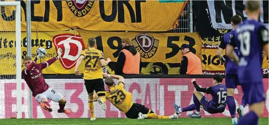  ?? Fotos: dpa/Robert Michael ?? Nicht zu halten für Dynamos Torwart Kevin Broll: In der 36. Minute erzielt Aues Marcel Bär die Führung für die „Veilchen“.