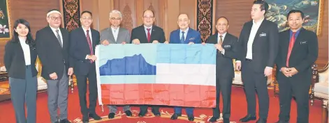  ?? ?? Hajiji (fourth right) receiving the Sabah flag that had been flown in Antarctica by Prof Dr Justin Sentian, witnessed by Prof Dr Mohammad Saffree (fifth from left) and Abd Shukor (fourth from left) at Menara Kinabalu on Tuesday.