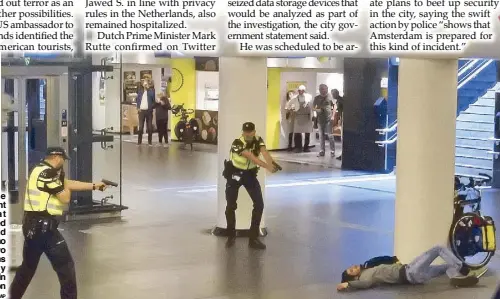  ?? AP ?? Dutch police officers point their guns at a wounded 19-year-old man who stabbed two Americans at a railway station in Amsterdam on Friday.