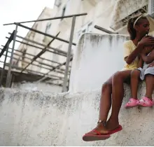  ?? (Photos: Reuters) ?? A WOMAN holds her daughter next to a synagogue that was damaged by a rocket, in Ashdod on August 22, 2014.