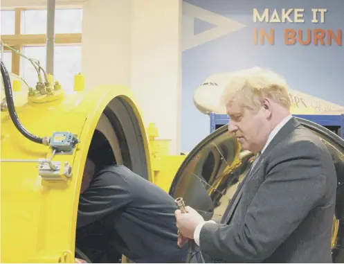  ?? ?? 0 Prime Minister Boris Johnson looks at a hose connecter during a campaign visit to Burnley College Sixth Form Centre in Burnley