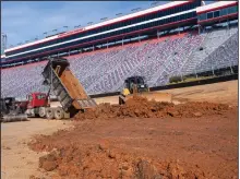  ?? (AP/Bristol Herald Courier/David Crigger) ?? Workers dump dirt onto the racing surface at Bristol Motor Speedway in this Jan. 14 photo. Bristol, once one of the toughest tickets in sports, trucked 23,000 cubic yards of dirt into the track to host NASCAR’s first Cup Series race on dirt in 70 years Sunday.