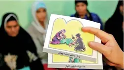  ??  ?? A counsellor holds up cards used to educate women about female genital mutilation (FGM) in Egypt. Reuters