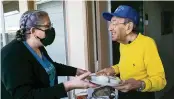  ?? MATIAS J. OCNER mocner@miamiheral­d.com ?? Rami Spiegel, left, gives food to Holocaust survivor Saul Dreier, 95, in Coconut Creek on Tuesday.
