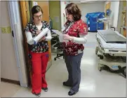  ?? DANA JENSEN/THE DAY ?? Nurse Andrea Walker, right, reports off on a patient at the end of her shift to coworker Amy Jurczyk at Lawrence + Memorial Hospital on Christmas Day.