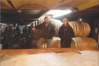  ??  ?? Jeffrey Stuffings, left, a founder of Jester King, and head brewer Averie Swanson stand over the coolship, where ambient microbes have begun fermenting lambic-inspired beer, at the brewery outside Austin.