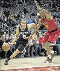  ?? JOHN AMIS / AP ?? Spurs guard Tony Parker drives past Hawks center Dwight Howard on Sunday. Parker scored 22 points, and Howard had six points and seven rebounds.