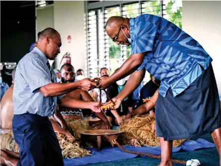  ?? ?? ANZ staff member Taito Rauluni handing over the tabua to Sitiveni Morovia.