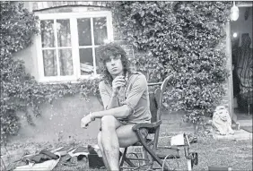 ??  ?? Rolling Stones guitarist Keith Richards smokes a cigarette in his garden after fire gutted Redlands, his West Sussex country house, in August 1973