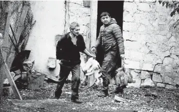  ?? SERGEI GRITS/AP ?? Ethnic Armenians carry chickens as they leave their homesWedne­sday in the village of Maraga, in the separatist region of Nagorno-Karabakh. A Russia-brokered cease-fire to halt weeks of fighting over Nagorno-Karabakh stipulated that Armenia turn over control of some areas it holds outside the separatist territory’s borders to Azerbaijan.