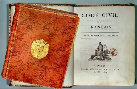  ??  ?? Ci-contre : Portrait de Napoléon Ier en costume de sacre (1769-1821). L’empereur prête serment sur le Code civil, appelé aussi Code Napoléon. Peinture de Anne-Louis Girodet, 1804.
Première édition du Code civil des Français, en 1804.