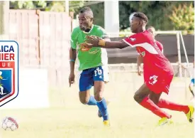  ?? FILE ?? In this file photo from January 2018, Montego Bay United’s Dwayne Ambusley (left) shrugs off Boys Town’s Shaquille Bradford to keep possession of the ball during their Jamaica Premier League game at the Barbican Sports Complex.