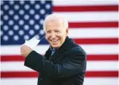  ?? ERIN SCHAFF/ THE NEW YORK TIMES ?? Joe Biden, the Democratic presidenti­al nominee, removes his face mask during a drive-in campaign event at the Iowa State Fairground­s in Des Moines, Iowa, on Friday.