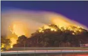  ?? Allen J. Schaben Los Angeles Times ?? TRAFFIC moves past the Saddleridg­e fire on Oct. 11. The blaze started near an Edison electrical tower.