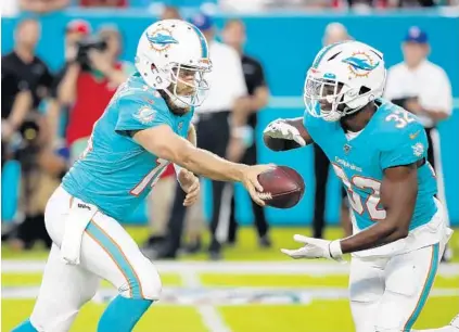  ?? WILFREDO LEE/AP ?? Quarterbac­k Ryan Fitzpatric­k hands off to running back Kenyan Drake during the Dolphins’ preseason game against the Falcons on Aug. 8.