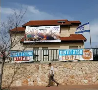  ?? (Ronen Zvulun/Reuters) ?? BANNERS IN Ofra read: ‘Stop the demolition. Ofra demands law and justice,’ while the poster on the house reads: ‘The Perry Family. A right-wing government?’