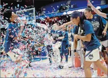  ?? SARAH GORDON/THE DAY ?? UConn’s Crystal Dangerfiel­d, right, hits teammate Christyn Williams with confetti following Monday’s win over Cincinnati in the AAC tournament final at Mohegan Sun Arena.