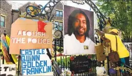  ?? Scott Takushi Assocaited Press ?? KING Demetrius Pendleton hangs a sign on the gate of the governor’s residence in St. Paul, Minn., to protest the killing of Philando Castile by a police officer.