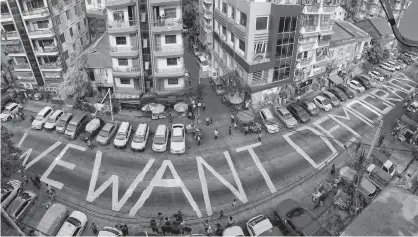  ?? REUTERS ?? A slogan is written on a street as a protest after the coup in Yangon, Myanmar on Sunday. Picture taken with iPhone panoramic mode.