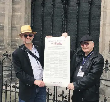  ?? RON BESTVATER ?? Pastor
Ron Bestvater and his father, Rev. JR Bestvater, at Castle Church in Wittenberg, Germany, holding an English translatio­n of Luther’s 95 Theses, which are inscribed on the doors behind them.