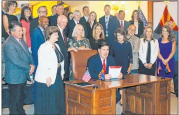  ?? Bob Christie The Associated Press ?? Arizona Gov. Doug Ducey signs what he and others say is the most significan­t water legislatio­n in 40 years as lawmakers and others look on Wednesday in Phoenix.