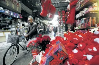  ?? LOUAI BESHARA/GETTY IMAGES ?? A man passes a shop selling red teddy bears in Damascus, Syria, on Tuesday. Several Russian military contractor­s were killed last Wednesday after the U.S. military launched air and artillery strikes after coming under attack.