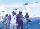  ?? LOLITA BALDOR AP ?? Defense Secretary Lloyd Austin (center) arrives on the aircraft carrier Nimitz on Thursday. Austin says he hopes to avoid long ship deployment­s.