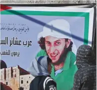  ??  ?? JERUSALEM: Palestinia­n boys look at a poster of 28-year-old Palestinia­n Fadi Al-Qunbar at his family home in the East Jerusalem neighborho­od of Jabal Mukaber yesterday, a day after he killed four Israeli soldiers in a truck-ramming attack before being...