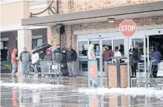  ?? /EFE ?? Varias personas hacen fila a pesar de las bajas temperatur­as para ingresar a un supermerca­do.