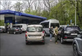  ?? KASIA STREK — THE WASHINGTON POST ?? People fuel their vehicles at a gas station near Kyiv, Ukraine, this month. Russia’s invasion is putting the world economy under enormous pressure.