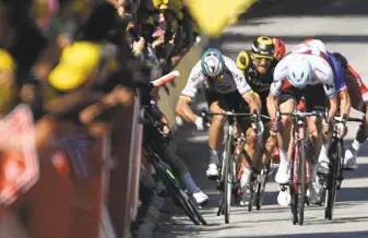  ?? Jeff Pachoud / AFP / Getty Images ?? Peter Sagan sticks out his elbow and Mark Cavendish (leg shown) falls near the finish line of the fourth stage. Sagan was disqualifi­ed from the Tour de France and Cavendish withdrew.