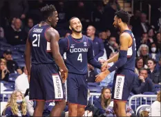  ?? Brady Klain / Getty Images ?? UConn’s Tyrese Martin (4), celebrates with teammates Adama Sanogo, left, and Tyler Polley during Thursday’s win at Butler in Indianapol­is.