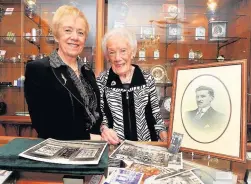  ??  ?? Great memories Shelving and counter is all original. Linda and Dorothy show a photo of the founder Henry Lyall