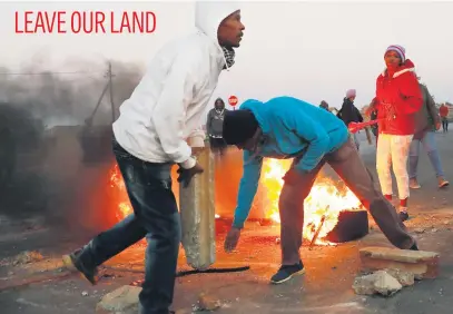  ?? Picture: EPA-EFE ?? Community members of Lenasia protest against the invaders of an open piece of land near their houses yesterday. The area has seen thousands of illegal shacks being erected over the past months.