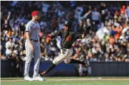  ?? JOSIE LEPE / AP ?? Thairo Estrada (right) races past Reds third baseman Brandon Drury on his way to scoring a Giants run in the fourth inning Saturday in San Francisco.