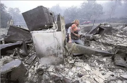  ?? Photograph­s by Luis Sinco Los Angeles Times ?? SHERI MARCHETTI-PERRAULT and James Benton sift through the remains of their Yreka, Calif., home after the McKinley fire.